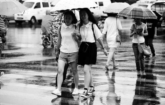 昨日早上迎來一場及時雨，市民清涼出行    本報記者代澤均攝