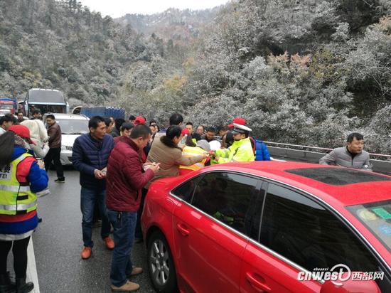安康交警为高速路上滞留司乘人员发放食物。