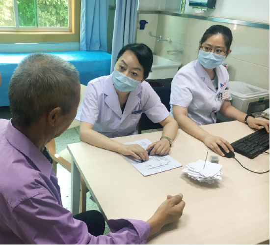 西安市中心医院消化内科主任医师庄坤正在询问患者相关病情