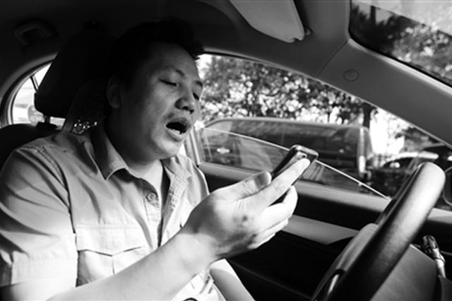 等座间隙,王小强拿出手机学新歌 本报记者 党运 摄