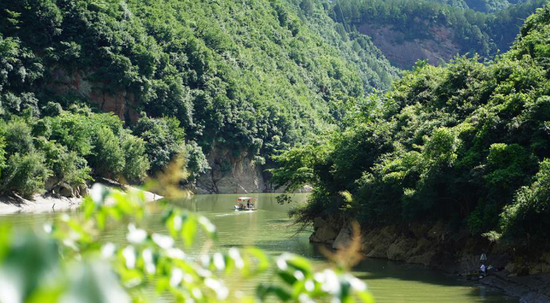 一艘游船行驶在灵官峡景区内的嘉陵江上