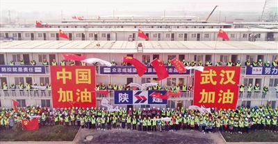 建設(shè)者們站在生活區(qū)的樓前,齊聲吶喊“中國加油 武漢加油” 王健 張紅中 攝