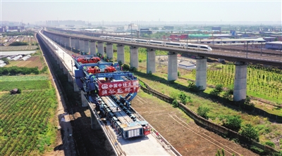 5月10日，工人在西银高铁咸阳渭河特大桥上架设全线最后一榀箱梁（无人机照片）。 新华社发