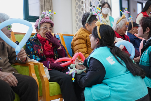 青年社区志愿队在敬老院开展与老人趣味拍照活动
