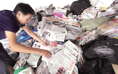 市民撿拾小區(qū)被扔掉的廢品紙張