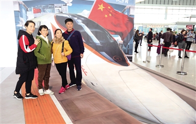 3月14日10時，從西安北開往成都東的全國首趟“時光列車”D1923次列車正式發車。這趟列車通過圖片展示等活動，讓旅客在旅途中感受新中國成立70年來的發展成就。圖為西安北站候車廳，旅客們在精心設計的立體繪畫前合影。 本報記者 陳飛波 攝