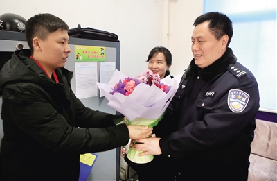 正月初一,15岁的张尚祺来到西安市公安局碑林分局红缨路派出所,将一束康乃馨送给坚守岗位的民警并向他们拜年。 本报记者 党运 摄
