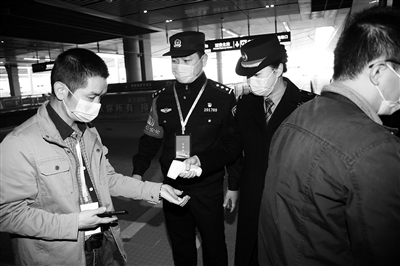 西安北站，工作人員在對55571次試驗動車組列車乘客進行體溫檢測。