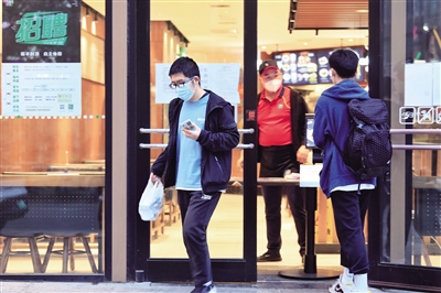 4月17日,记者在西安市南稍门附近的部分餐饮店外看到,餐馆的门口都用餐桌设置了隔档,一些顾客正在取餐。 本报记者 王晓峰 摄