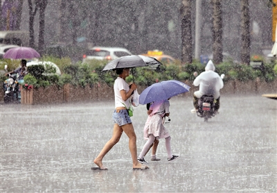 　　7月2日，雨中出行的市民 本报记者 代泽均 摄