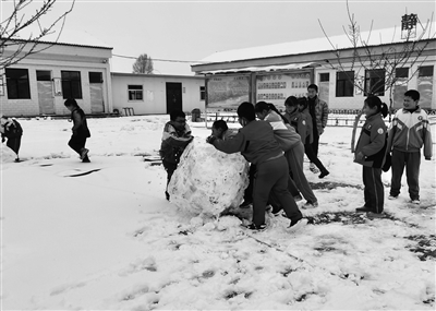 定边县罗庞塬小学操场上，学生们在滚雪球 朱金鹏 本报记者 代泽均 摄