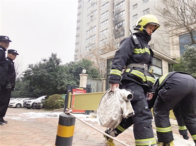 消防员铺设水带灭火 首席记者 葛兰摄