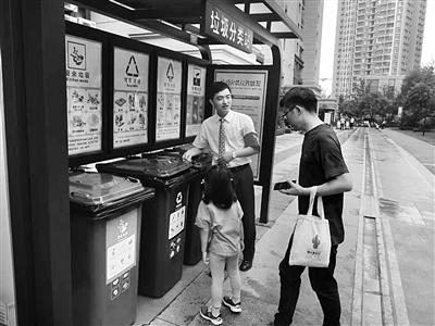 工作人員指導居民分類扔垃圾