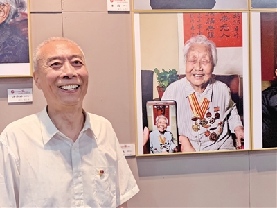昨日,5位摄影师拍摄的百位百岁老人肖像在西安展出。图为市民郭建民讲述101岁的母亲白冰的故事 本报记者 石喻涵 摄