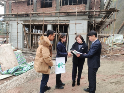 图：工作人员走村入户普及金融保险知识