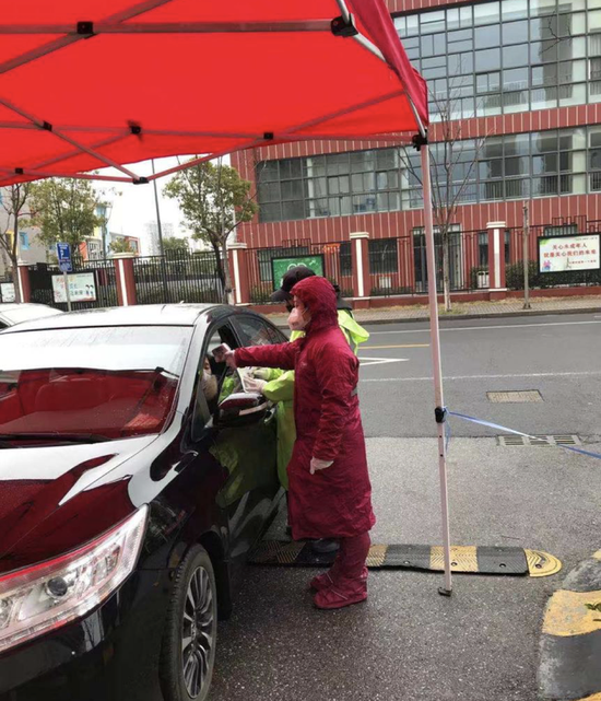 蒋雅婷正在为小区出入人员测温