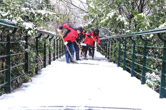 从昨天凌晨起,张家港、常熟等地下起了雪,地面出现积雪。图为市民在铲雪。 □季绍秦 摄