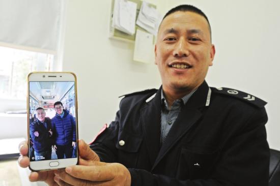 昨天,苏州市公交308路驾驶员仲崇赶展示他和小伙子的合影。□记者 杭兴微 摄