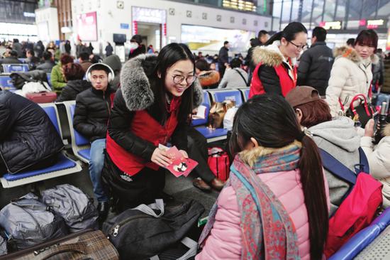 来自苏州市未成年人健康成长指导中心的“苏老师”向旅客派发宣传资料。□记者 倪黎祥 摄