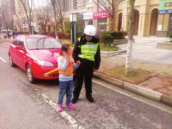 园区交警大队辅警周俊怡拉着小女孩的手帮她找妈妈。朱萍/摄