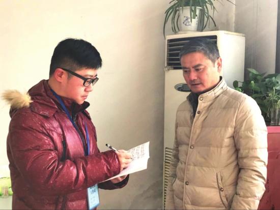 朱越(左)正在记录居民意见建议。 □陆蓉 摄