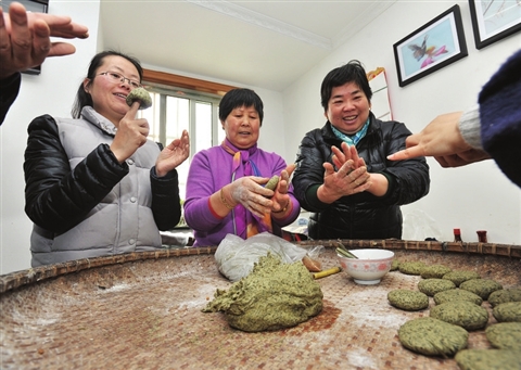 金阊新城富强新苑的袁阿姨(右一)教社区新苏州人做草头饼。 □记者 徐志强 摄