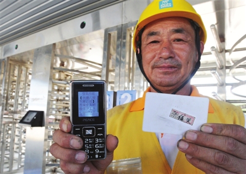 昨天,务工人员张伍贤在向记者展示手机上收到的考勤统计信息。