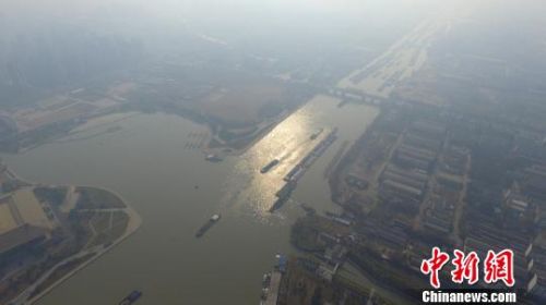 图为雾霾笼罩下的京杭大运河扬州段,来往船只川流不息。 孟德龙 摄