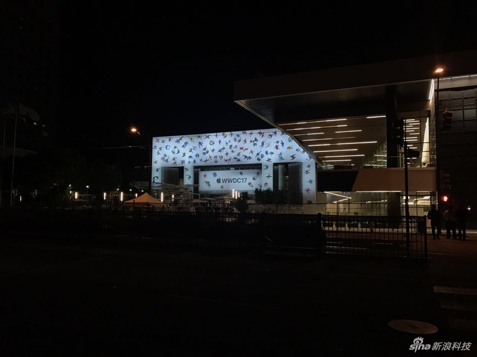夜幕降临，会场主要道路已经封锁，人们无法靠近，只能趁着灯光，远远地看上几眼。