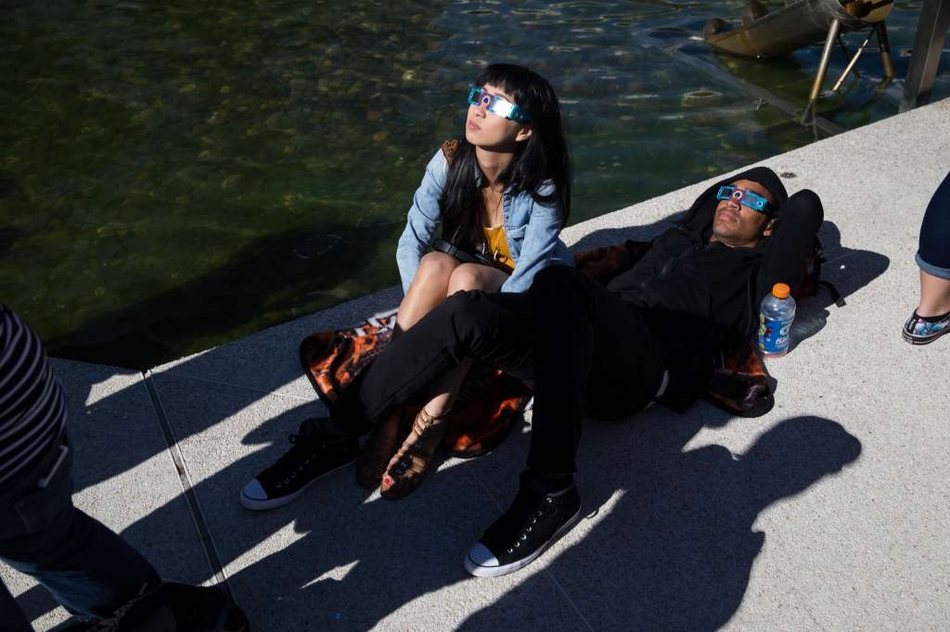 一对夫妇在西雅图太平洋科学中心观赏日食。