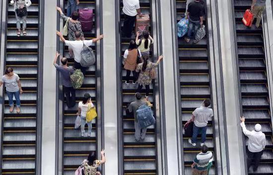 北京西站,旅客乘电梯到二层候车厅候车(图片来源:视觉中国)