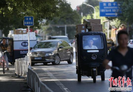 9月6日，北京街头，一位快递小哥驾驶着满载货物的电动车行驶在路上。中国青年报·中青在线记者 陈剑/摄