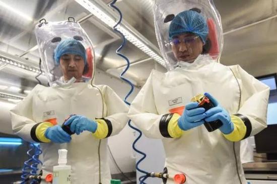 图6 身穿正压防护服的科研人员在武汉P4实验室进行适应性演练 拍摄：肖宇宙
