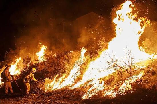 2018年，加州埃尔西诺湖的消防员正在扑灭山火。这场山火最后烧毁了9300公顷的土地。
