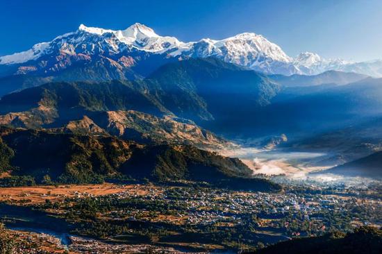 喜马拉雅山脉南麓尼泊尔境内的雪山和森林，岩石风化形成山区薄薄的土壤，孕育植被。 　　图源@VCG