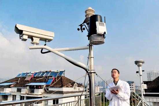 （资料图片）工作人员在观察环境空气质量监测设备运行情况。图/ 视觉中国