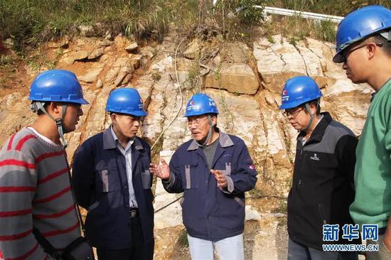 南仁东（左三）与工程技术人员在位于黔南州平塘县的大窝凼施工现场检查施工进展（2014年12月1日摄）。图片来源：新华网