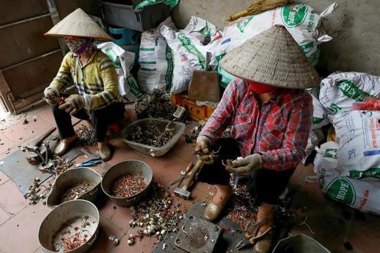 在越南的一个村庄里,妇女们正将电子垃圾分类以用于回收。来源:Nguyen Huy Kham/Reuters