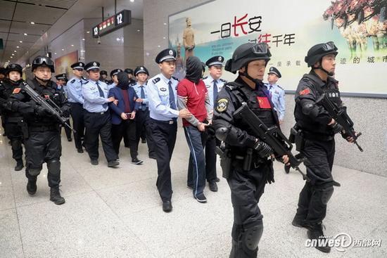 警方荷枪实弹押回嫌犯。 西部网 图