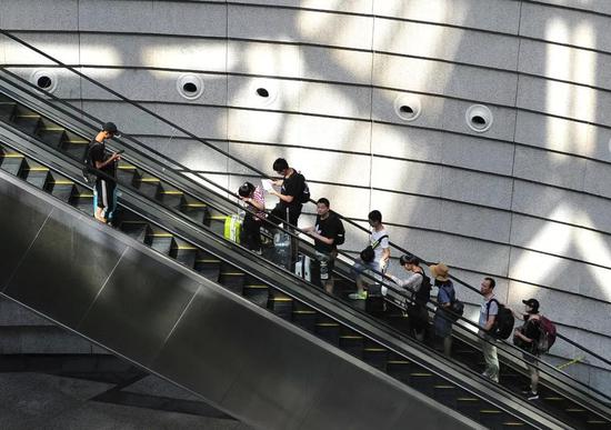 南京禄口国际机场里乘坐自动扶梯上下的旅客（图片来源：视觉中国）