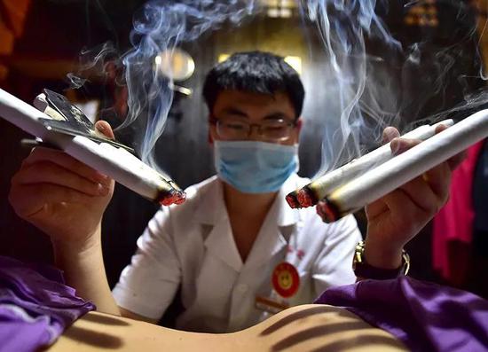 浙江一名中医执业者在为病人治疗（来源：China Daily/Reuters）