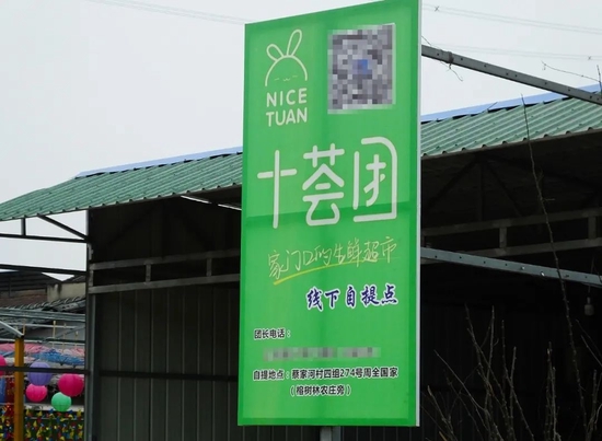 ▲ 湖北宜昌，商家在门店前张贴的十荟团海报。图 / 视觉中国