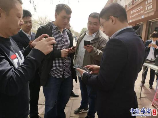 游客纷繁上前了解5G手机。雄安移动供图