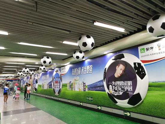 北京地铁一号线通道内布满了足球造型及广告。来源：视觉中国
