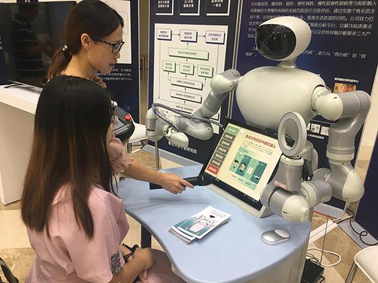 罗静静博士向体验者演示中医体检机器人。 澎湃新闻见习记者 朱奕奕 图