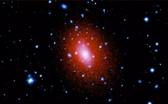 星系之外：这个不起眼的斑点就是星系团阿贝尔2029（Abell 2029），同时用可见光和紫外线拍摄。这样的星系团是我们的宇宙中最大的结构。图片来源：NASA/Chandra X-ray Center/IoA