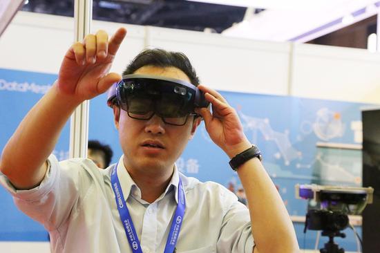 观众在2017中国互联网大会上体验全息眼镜Hololens。
