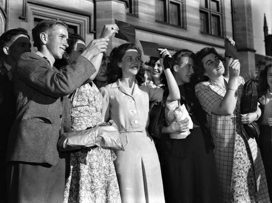 ▲ 悉尼大学的学生在 1948 年 10 月 31 日通过看纸板和胶片观看日食，以保护他们的眼睛不受日光的影响。（The Sydney Morning Herald / Getty Images）