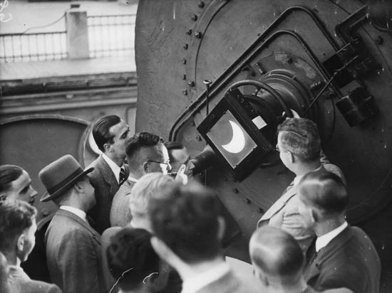 ▲ 1936 年，柏林 Treptower 天文台的参观者通过望远镜见证了日食奇观。（Imagno / Getty Images）