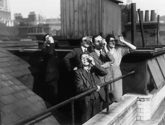 　▲  1921 年 4 月 9 日，伦敦的城市工人在办公室屋顶看日食。（Topical Press Agency / Getty Images）